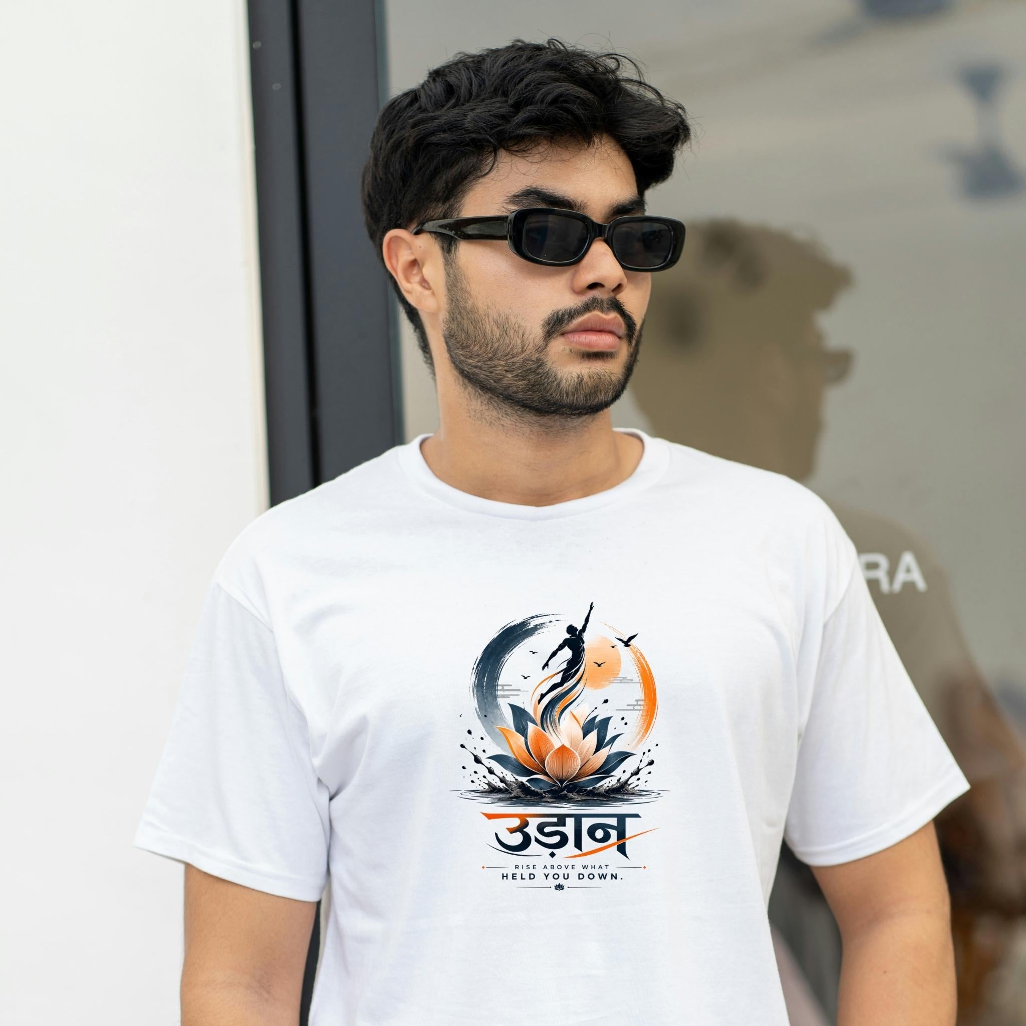 Man wearing UDAANT Oversized Graphic Tee - Lotus Rise Motivational T-Shirt in white with black sunglasses, street-style outfit